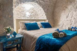 Un dormitorio con una cama con almohadas azules y una mesa. en Azzurro Come Te - Ostuni, en Ostuni