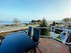 patio con mesa y sillas en el balcón en BEACH HOUSE-Traumwohnung in Bestlage mit herrlichem Meerblick, en Harrislee