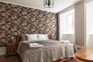 Un dormitorio con una cama con papel pintado floral. en Divine Living - Apartments, en Estocolmo