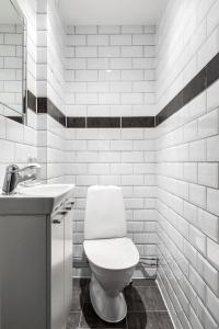 a white bathroom with a toilet and a sink at Divine Living - Apartments in Stockholm