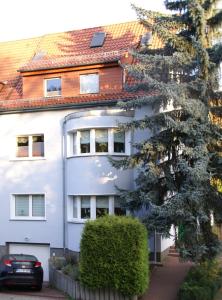 ein weißes Gebäude mit einem davor geparkt in der Unterkunft Apartment Erfordia Erfurt am Egapark in Erfurt