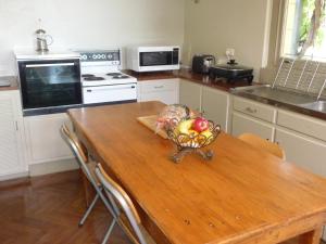 a kitchen with a wooden table with a bowl of fruit on it at Country Bakehouse Accommodation in Spalding