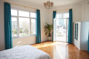 a bedroom with blue curtains and a bed and a window at Great View of Taksim Square, Luxury Furnished on Main Street of Taksim, Partial Sea View in Istanbul
