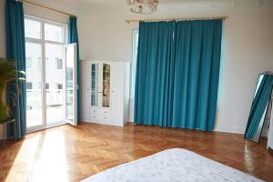 a bedroom with blue curtains and a wooden floor at Great View of Taksim Square, Luxury Furnished on Main Street of Taksim, Partial Sea View in Istanbul