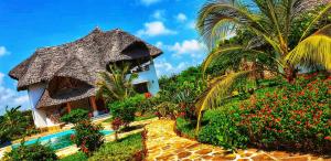 a house with a garden and a swimming pool at Nyumba Nicole in Watamu