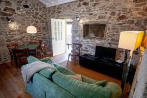 a living room with a couch and a tv at Casas de São Martinho in Arcos de Valdevez