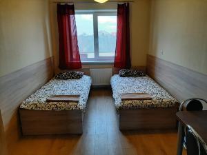 two beds in a small room with a window at ROOMS FOR RENT in Panevėžys