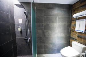 a bathroom with a shower and a toilet in it at The Leaf Inn in Hualien City