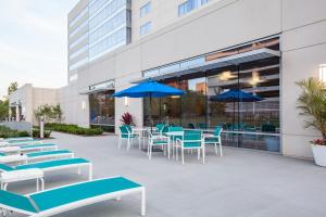 a patio with blue and white chairs and tables and umbrellas at Holiday Inn Cleveland Clinic, an IHG Hotel in Cleveland