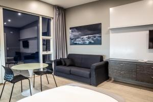 a living room with a couch and a table at Black Beach Suites in Vík