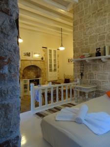 una camera con letto e un soggiorno con camino di Muse Mese a Calchi (Halki)