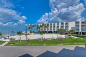un grand bâtiment avec des palmiers et un parking dans l'établissement Casa de Playa - Waterfront with Amazing Sunset, Pool and WIFI, à Tampa