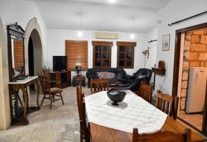 uma sala de estar com um sofá, uma mesa e cadeiras em Lasa Black Rock villa em Pafos