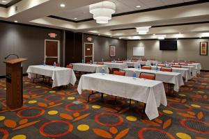 a conference room with tables and chairs and a podium at Holiday Inn Columbus-Hilliard, an IHG Hotel in New Rome