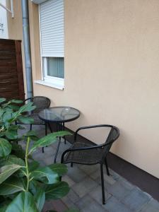 three chairs and a table on a patio at Bodza Apartmanok in Eger