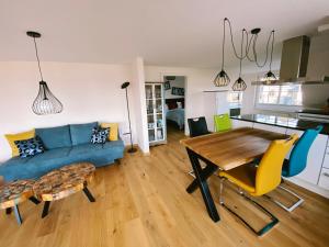 ein Wohnzimmer mit einem blauen Sofa und einem Tisch in der Unterkunft BEACH HOUSE-Traumwohnung in Bestlage mit herrlichem Meerblick in Harrislee