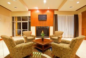 sala de estar con sillas, mesa y TV en Holiday Inn Aurora North - Naperville, an IHG Hotel, en Aurora