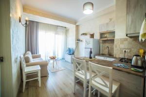 a kitchen and living room with a table and chairs at Comfy Apartment in Tbilisi City