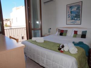 a bedroom with a bed with towels and a balcony at Locanda Lighea Rooms in San Vito lo Capo