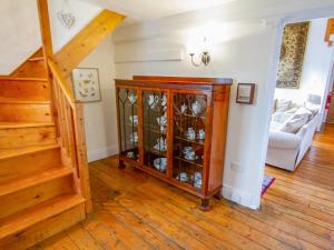 a living room with a staircase and a cabinet with glasses at The Old Chapel in Shelve