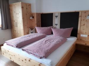a bed with two pillows on it in a room at Singerhof in Fulpmes