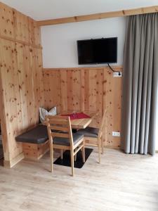 a dining room with a table and chairs and a tv at Singerhof in Fulpmes