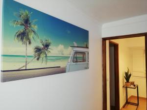 a painting of a beach with palm trees on a wall at Casa Ferry Trafaria in Trafaria