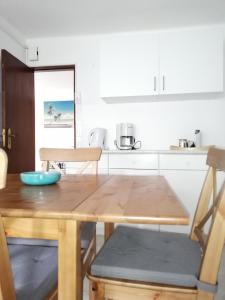 einen Holztisch mit 2 Stühlen und eine Küche in der Unterkunft Casa Ferry Trafaria in Trafaria