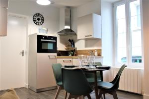 a kitchen and dining room with a table and chairs at Pontivy Centre, Studio Confort in Pontivy