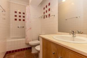 un bagno con lavandino, WC e specchio di Villa Blue Garden by ALGARVEMANTA a Manta Rota Altre 24 foto