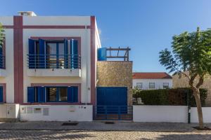 una casa con porte blu e un albero di Villa Blue Garden by ALGARVEMANTA a Manta Rota