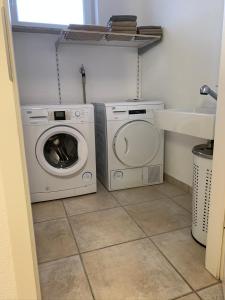 eine Waschküche mit einer Waschmaschine und einem Waschbecken in der Unterkunft Luxus-Apartment Quierschied in Quierschied