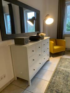 a living room with a dresser with a mirror at Luxus-Apartment Quierschied in Quierschied