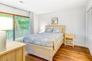 a bedroom with a bed and a balcony at Night Heron 4117 in Kiawah Island