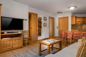 a living room filled with furniture and a tv at Chalet Stelle Di Neve in Bormio