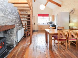 a kitchen and dining room with a table and a fireplace at Dovetail Cottage in Llangollen