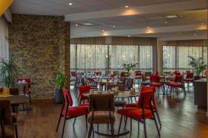 une salle à manger avec des tables et des chaises rouges dans l'établissement Oceania Quimper, à Quimper