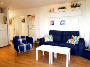 a living room with a blue couch and a table at Apartamento Jumilla Vista Mar 22 in Playa del Ingles