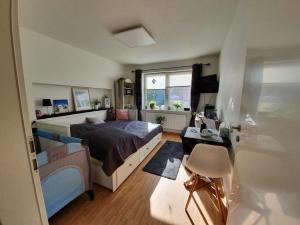 a bedroom with a bed and a desk and a window at Zentrales Zimmer auf dem Land in Großsolt