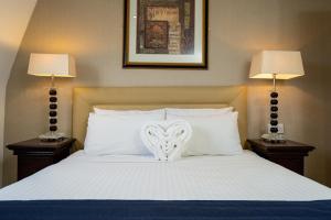 a white bed with a white bedspread and pillows at The Clarendon Hotel in London