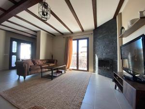 uma sala de estar com um sofá e uma televisão em Alojamiento Rural El Refugio em Genalguacil