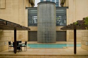 a patio with a table and chairs in front of a building at 207 Raphael Penthouse in Johannesburg
