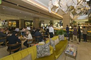 grupa ludzi siedzących przy stolikach w restauracji w obiekcie 207 Raphael Penthouse w mieście Johannesburg