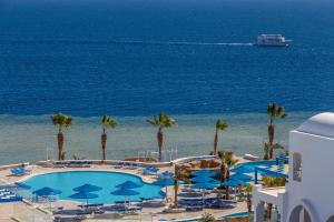 vista su una piscina e sull'oceano con nave da crociera di Pickalbatros Palace Sharm - "Aqua Park" a Sharm El Sheikh