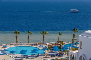 a view of a pool and the ocean with a cruise ship at Pickalbatros Palace Sharm - "Aqua Park" in Sharm El Sheikh