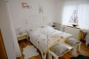 a bedroom with a white bed and a window at Haus Alfina in Alf