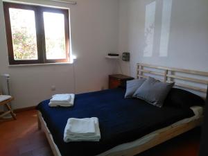 a bedroom with a bed with two towels on it at Patio Beach House - Checkinhome in Castro Marim