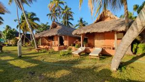 a house with a thatched roof with a hose at LE TRANSAT in Ambatoloaka