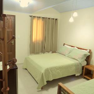 a bedroom with two beds and a window at Recanto Abayomi in Ilha do Mel