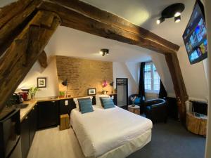 een slaapkamer met een bed en een tv in een kamer bij Hôtel De La Cathédrale in Rouen